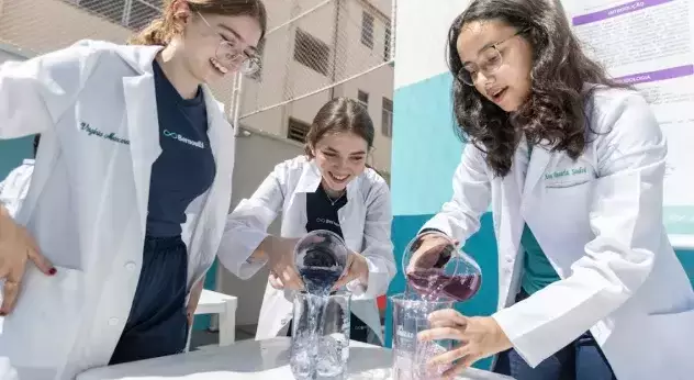 Estudantes do Colégio Bernoulli em aula prática de Ciências, realizando uma experiência. 